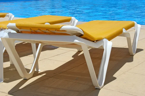 Pool restbeds closeup and blue water — Stock Photo, Image
