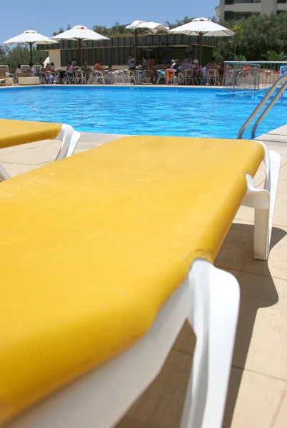 Pool restbeds closeup with pool water and bar as background — Stock Photo, Image