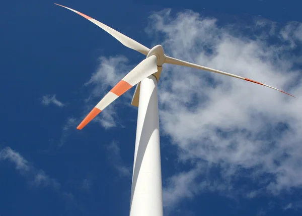 Wind mill power generator against a cloudy blue sky — Stock Photo, Image
