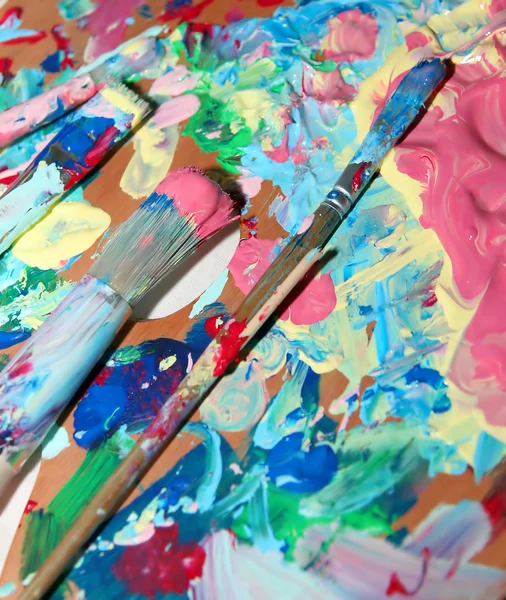 Malíř paleta s mnoha smíšených barev — Stock fotografie