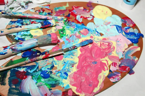 Paleta de pintor con muchos colores mezclados — Foto de Stock