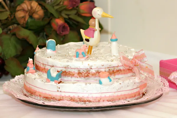 Baptism cake with small figurines and a stork on top — Stock Photo, Image