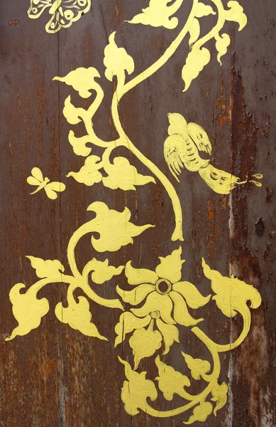 Золотая картина на старой деревянной двери — стоковое фото