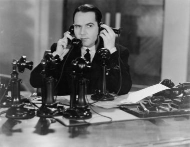 Man using two telephones