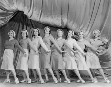 Portrait of line of female dancers on stage clipart