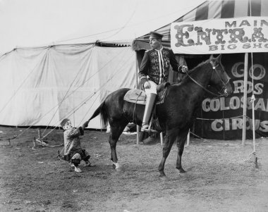 Circus performer pulling horses tail clipart