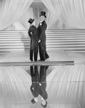 Couple posing in tuxedos and reflection clipart