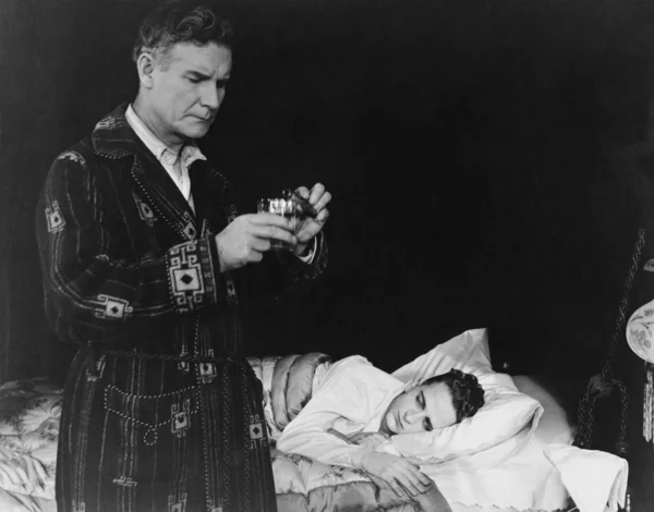 Przygotowanie leku dla chorych syna ojca — Zdjęcie stockowe