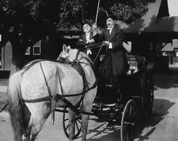 Cavalheiros dirigindo carruagem com cavalo engatada para trás — Fotografia de Stock