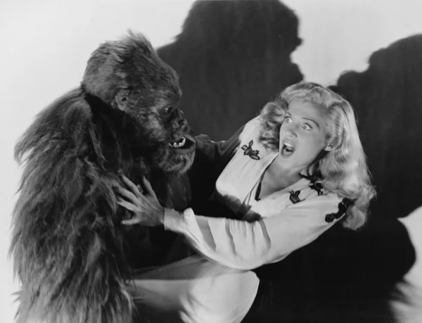 Skräckslagen kvinna attackeras av gorilla — Stockfoto