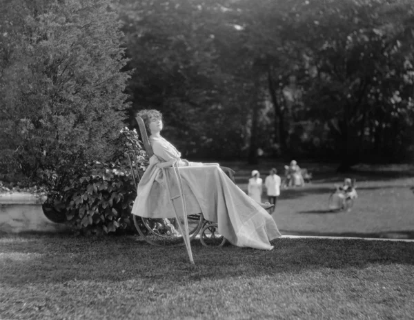 Paciente feminina em cadeira de rodas relaxante no jardim — Fotografia de Stock