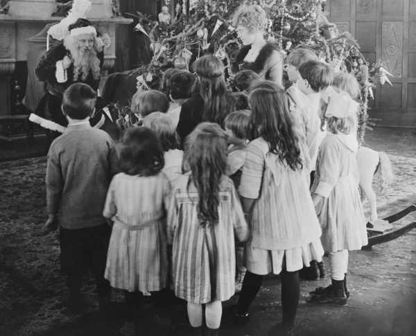 Santa Claus visiting with large group of children — Zdjęcie stockowe
