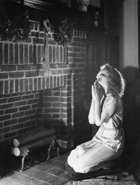 Portret nastolatka, modląc się w palenisko z obsady Boże Narodzenie — Zdjęcie stockowe
