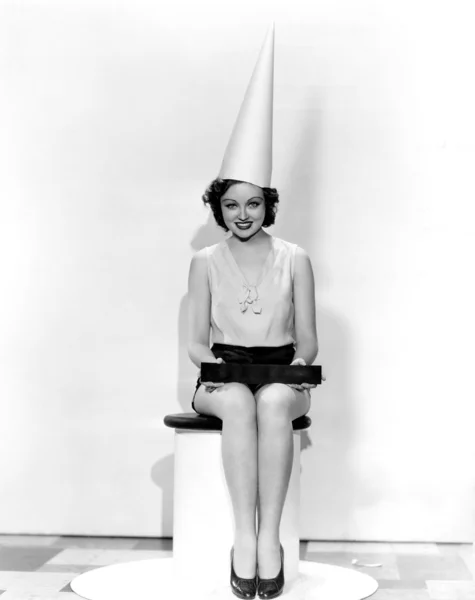 Porträtt av kvinna med aprilskämt tecken bär dumbom cap — Stockfoto