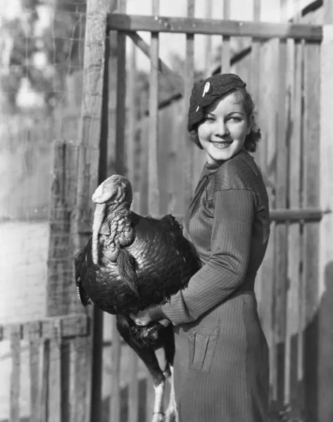 Smiling woman holding live turkey — Stock Photo, Image