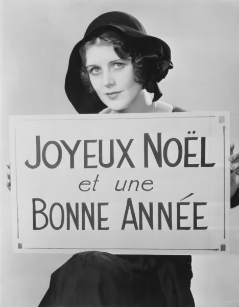 Retrato de una mujer sosteniendo un cartel escrito en francés — Foto de Stock