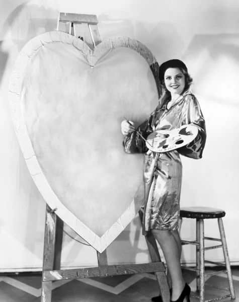 Vrouw schilderij enorme valentine — Stockfoto
