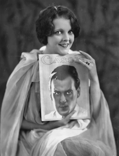 Woman with portrait of man on magazine cover — Stock Photo, Image