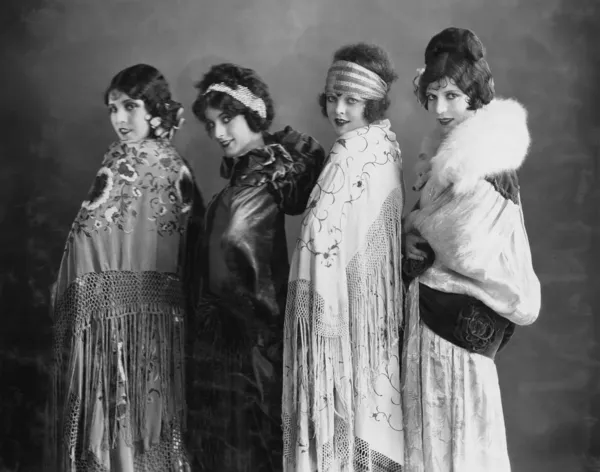 Портрет четырех молодых женщин, позирующих в шалях — стоковое фото