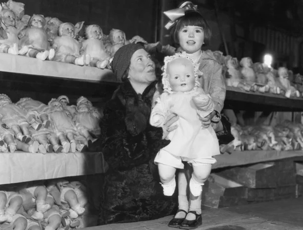 Mãe e filha com prateleiras de bonecas — Fotografia de Stock