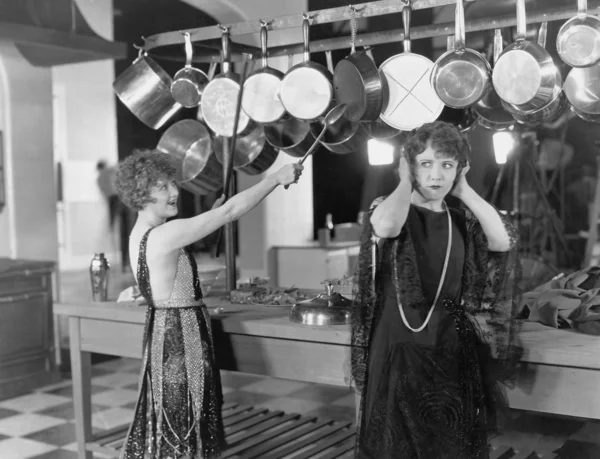 Kobieta w kuchni, pokonując na garnki i panswoman w kuchni, pokonując na garnki i patelnie — Zdjęcie stockowe