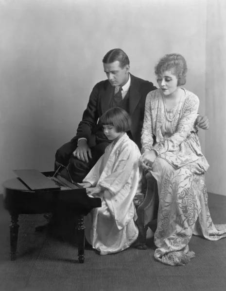 Γονέων, ακούγοντας την κόρη παίζω πιάνο μινιατούρα — Φωτογραφία Αρχείου
