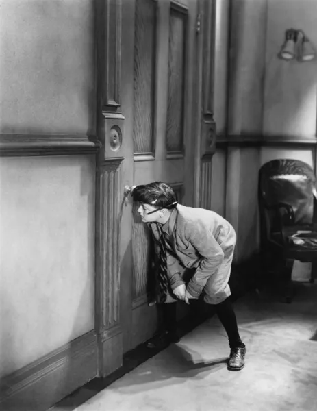 Nastoletni chłopiec ciekawski przez dziurkę od klucza — Zdjęcie stockowe