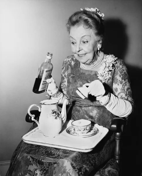 Idoso mulher spiking seu chá — Fotografia de Stock