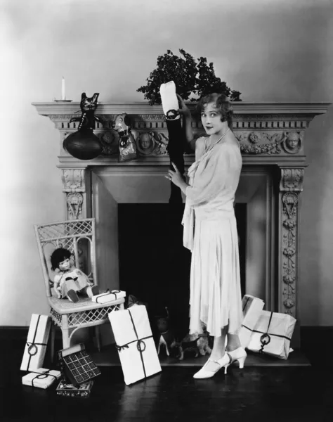 Woman stuffing Christmas stocking — Stock Photo, Image