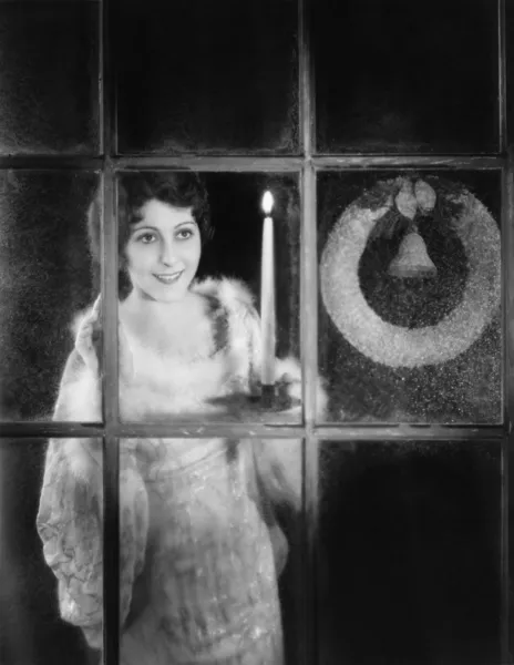 Frau mit Kerze und Adventskranz im Fenster — Stockfoto
