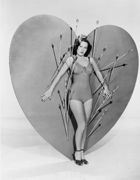 Mulher cercada por flechas no coração enorme — Fotografia de Stock