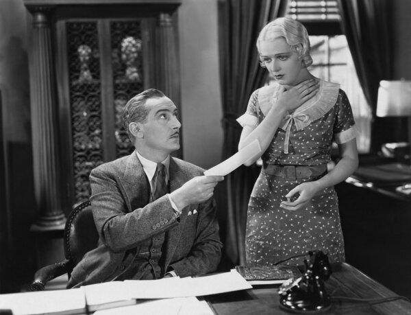 Businessman handing paper to stunned woman