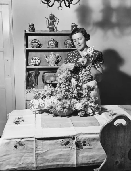 Kadın evde çiçek düzenliyor — Stok fotoğraf