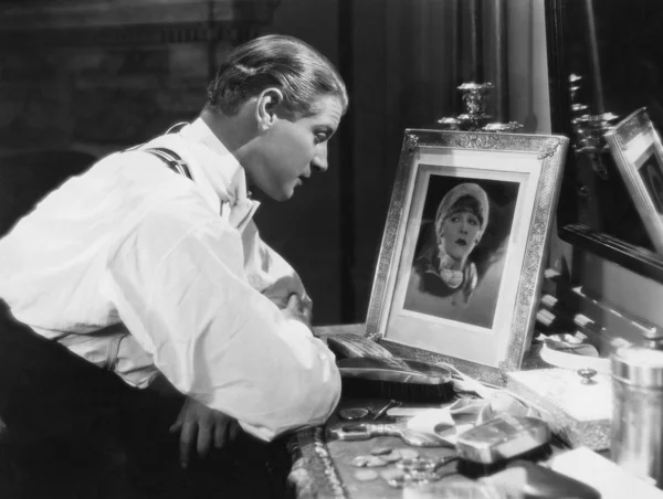 Мужчина смотрит на портрет женщины — стоковое фото