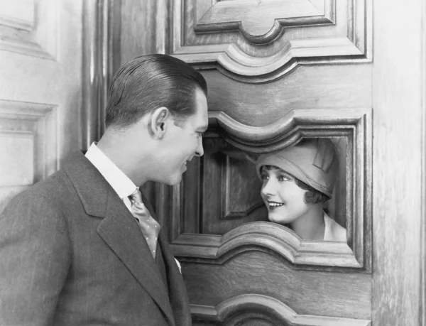 Paar interagiert durch Loch in Tür — Stockfoto