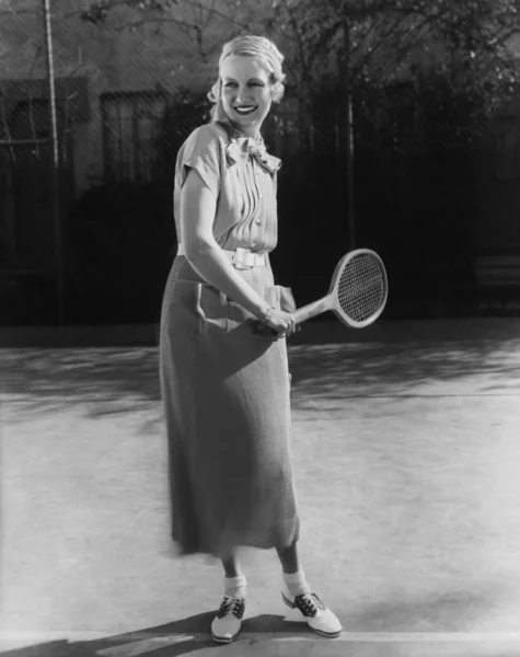 Улыбающаяся женщина играет в теннис — стоковое фото