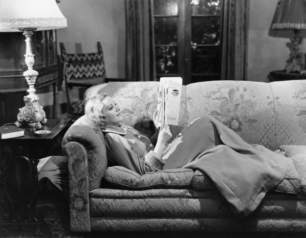 Kanepede kitap okuyan kadın — Stok fotoğraf