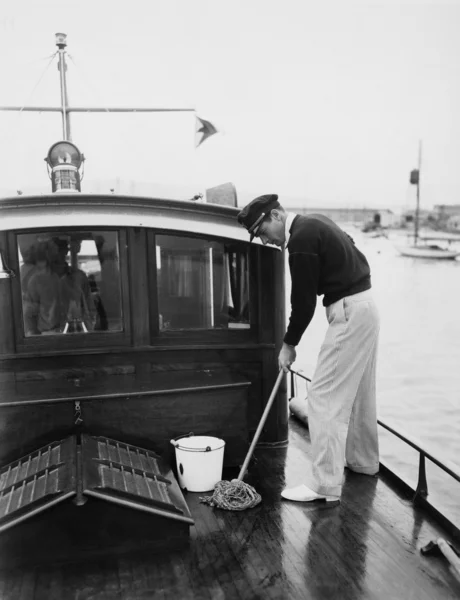 Homem esfregando deck de barco — Fotografia de Stock