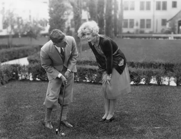 Чоловік розмовляє з жінкою під час гольфу — стокове фото