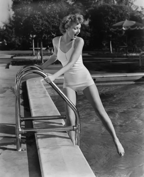 Donna immergendo le dita dei piedi nella piscina all'aperto — Foto Stock
