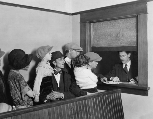 Семьи, стоящие в очереди у окна
