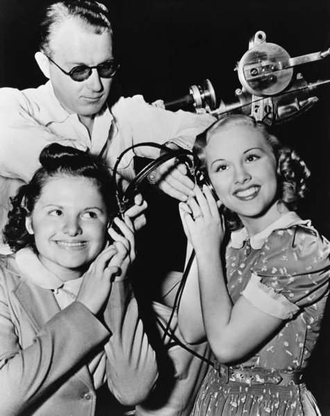 Γυναίκες μοιράζονται ζευγάρι ακουστικά — Φωτογραφία Αρχείου