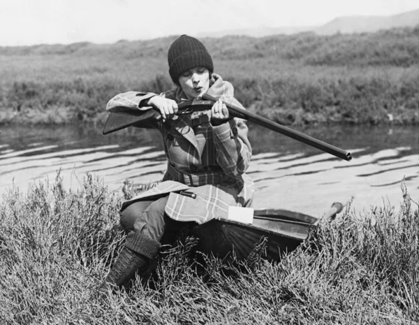 Γυναίκα κυνηγός με όπλο κοντά σε Ποταμός — Φωτογραφία Αρχείου