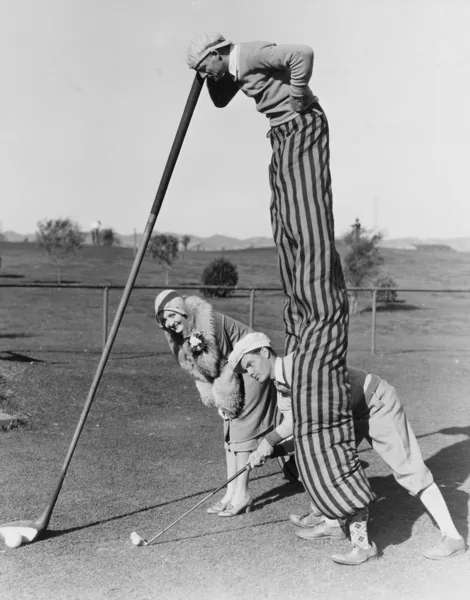 Golfspel met man op stelten — Stockfoto