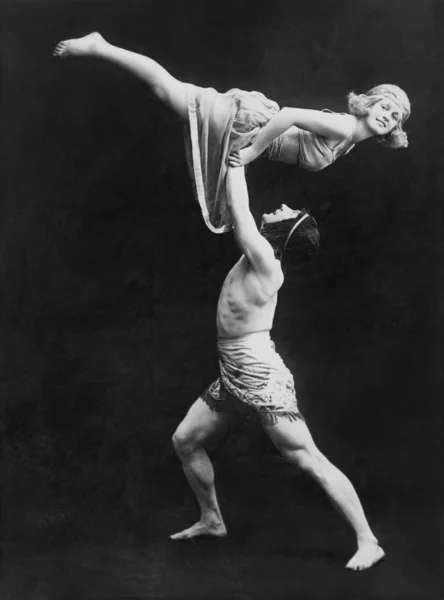 Bailarina masculina sosteniendo a la bailarina en alto Imagen de archivo
