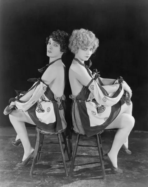 Dos mujeres seductoras espalda con espalda Imagen de archivo