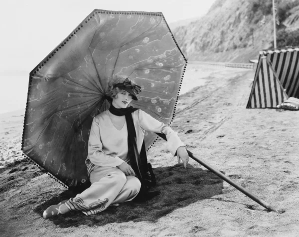 Frau mit Sonnenschirm am Strand lizenzfreie Stockfotos