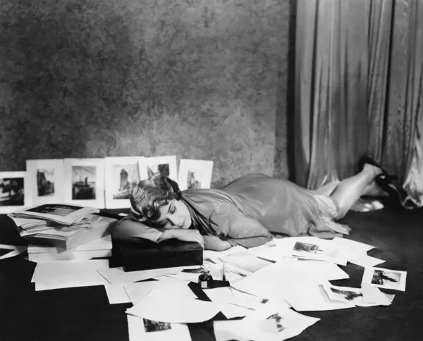 Vrouw in slaap op verdieping omringd door illustraties Stockfoto