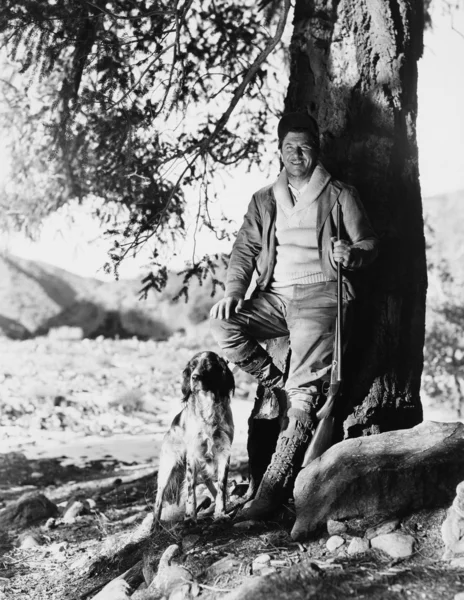 Portrait of hunter and dog under tree — Stock Photo, Image