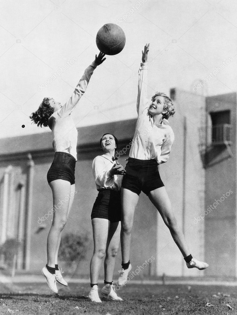 Three women with basketball in the air